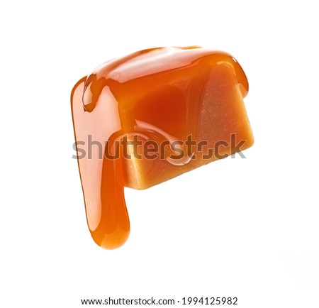 caramel sauce flowing on levitating caramel candy isolated on white background Royalty-Free Stock Photo #1994125982