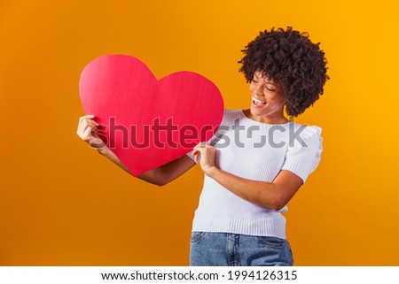 Photo portrait of smiling afro woman holding big red heart card