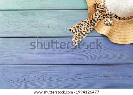 summer background: straw hat on a light blue wooden background