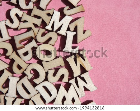 wooden letters of the English alphabet on pink suede as a background. High quality photo