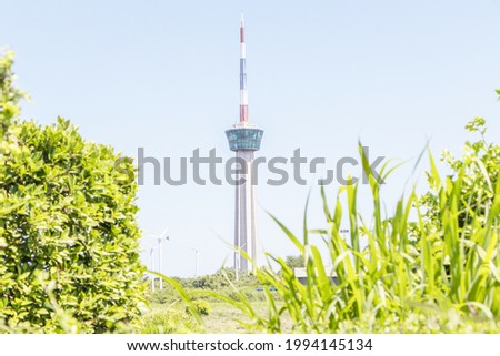 Remote photo Lighthouse and traffic control tower cargo ship sailing as national flag picture with clouds a background there is a blurred green tree in front. symbol of the port of Lamchabang.