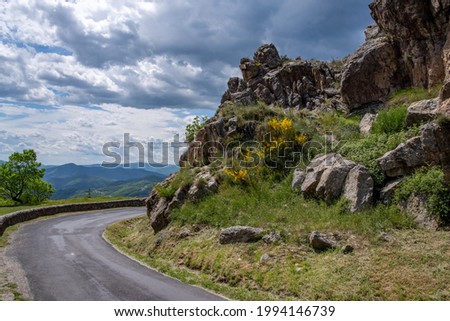 View into the landscape of the southern French Cevennes with a mountain road in the foreground. Royalty-Free Stock Photo #1994146739