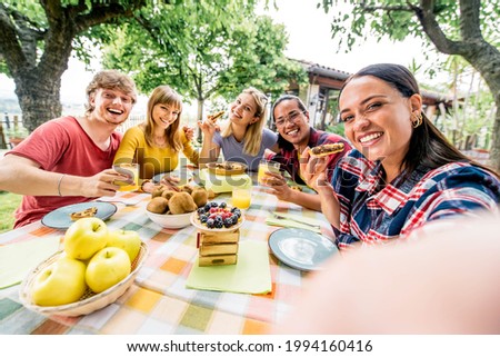 Happy multiethnic friends taking a selfie with phone at pic nic garden party - Young people having fun eating healthy food at bio organic restaurant - Friendship and youth concept