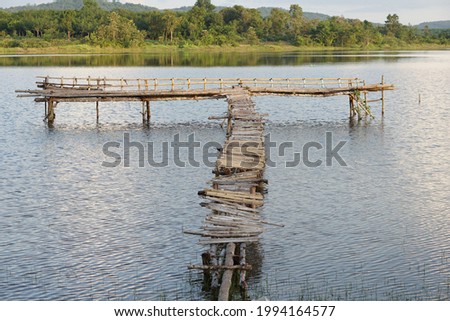 An old bamboo bridge jutting into the river For tourists taking pictures and enjoying the view