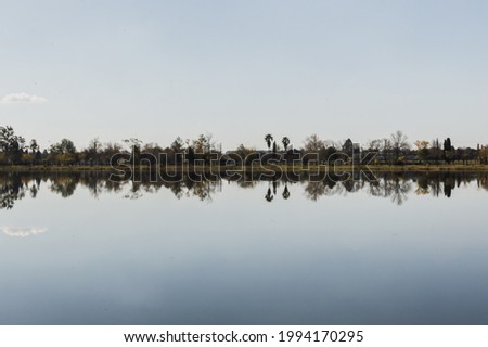 Horizon reflected in lake with a single cloud