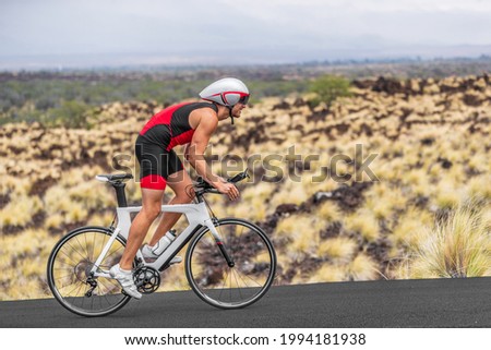 Cycling sport athlete man biking on triathlon bike. Fit male cyclist on professional triathlon bicycle wearing time trial helmet for iron man race exercising in Kailua Kona, Big Island, Hawaii, USA. Royalty-Free Stock Photo #1994181938