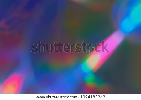 Defocused film texture background with colored lights on dark background. Blurred rainbow color light flare for photo effects