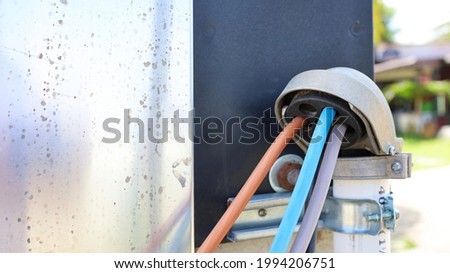 Service Entrance Cap with wire. Galvanized metal pipe with assorted colored wires beside concrete columns and silver control cabinet with copy space. Selective focus