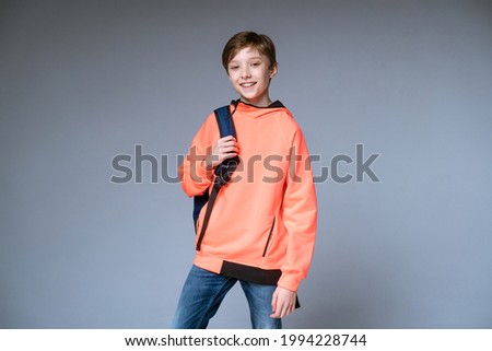 guy teenager posing with backpack on gray background
