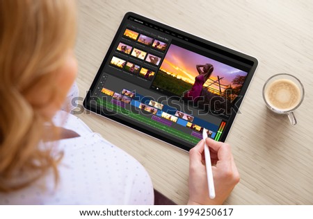 Woman editing video footage on tablet computer