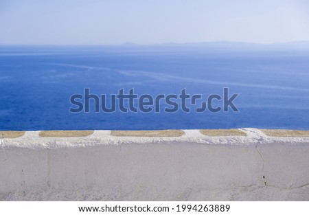 Calm sea, clear blue sky, view over a white stone parapet wall. Spectacular view to Aegean Sea, Cyclades Greece. Folegandros island outlook terrace. Copy space, summer vacations card template Royalty-Free Stock Photo #1994263889