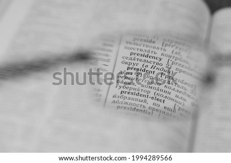 Reading glasses and an open book in close-up. Old Russian-English Dictionary. Selective Focus on the word PRESIDENT.