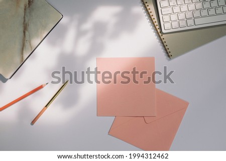 Congratulation square paper card  with soft shadows on office desk with stationery. Marketing, wedding and email newsletter concept.