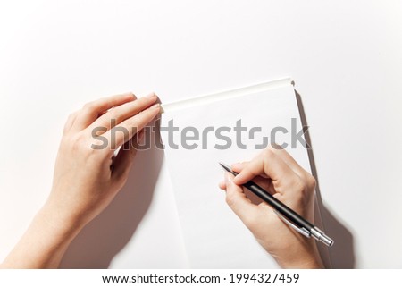 top view of blank notepad and hands 
