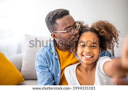 Family is the most important thing. Self portrait of young father and his little daughter smiling. Smiling father with little cute preschool daughter looking at smartphone screen taking making selfie 