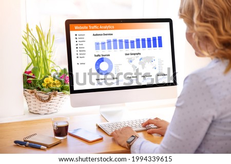 Woman looking at website traffic analytics data on computer Royalty-Free Stock Photo #1994339615