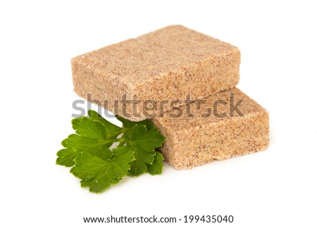 Bouillon cubes, with parsley in closeup, isolated on white background