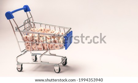 Metal cart with wooden cubes with the English alphabet inside on a white background. Background with letters for copywriting.