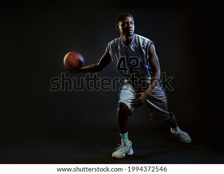 Muscular basketball player, black background
