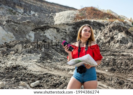 tourist woman look the map among the stones with camera