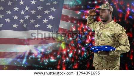 Composition of male soldier saluting over american flag and fireworks. american patriotism, independence and celebration concept digitally generated image.