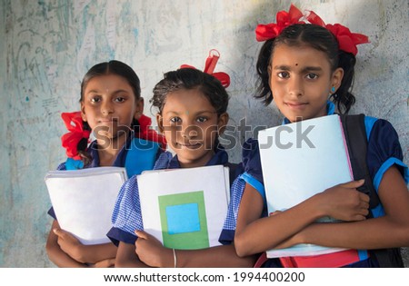 Indian Rural School Girls Holding Books Standing in School Royalty-Free Stock Photo #1994400200