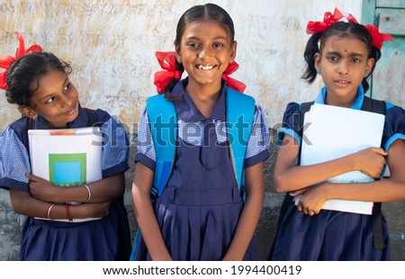 Indian Rural School Girls Holding Books Standing in School Royalty-Free Stock Photo #1994400419