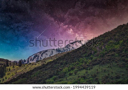 A vibrant shot of pink and blue toned majestic starry sky seen through mountains