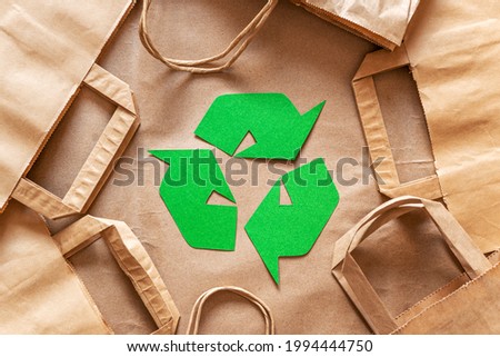 Recycled packaging ,craft packages for packaging goods from online stores, eco friendly packaging made of recyclable raw materials, green arrow recycling symbol Royalty-Free Stock Photo #1994444750