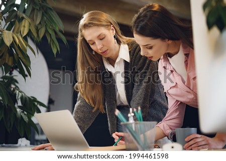 Two young women working together in office