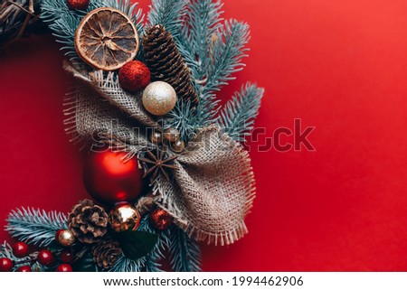 Red festive background with Christmas wreath. New Year.
