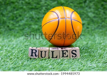 Basketball and word RULES are on green grass