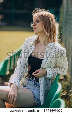 Woman cheerleader sitting at the football field