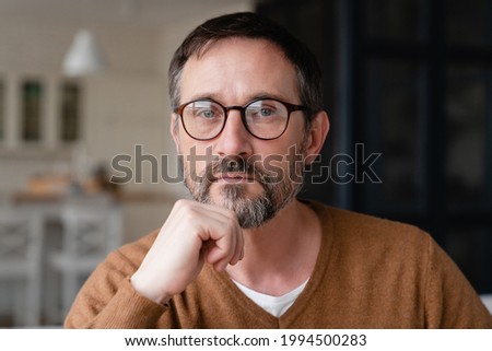 Front view portrait of a confident thoughtful pensive Caucasian middle-aged mature man teacher father freelancer wearing glasses looking at camera at home. Royalty-Free Stock Photo #1994500283