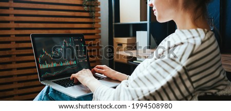 Woman investing in world stock market, using her laptop and online trading soft from home Royalty-Free Stock Photo #1994508980