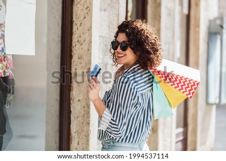 Happy curly hair woman shopping with her credit card.