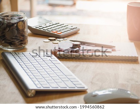 Office workplace with calculator laptop keyboard mouse and moneys on wood table. business finance concept.
