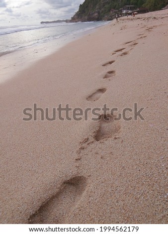 footprints left on the white sand beach