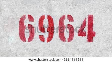 Red Number 6964 on the white wall. Spray paint. Number six thousand nine hundred and sixty four.
