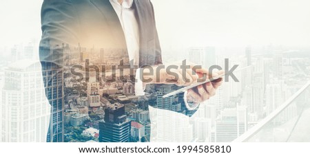 Businessman and a city using a tablet over white background. Business assistance businessman career cityscape design double exposure. internet of things network concept.
