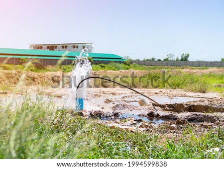 The water flowing artesian well after  hole drilling machine installed for the water supply. Royalty-Free Stock Photo #1994599838