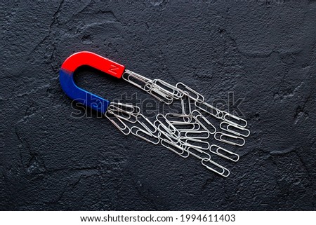 Horseshoe magnet collecting paper clips. Office supplies top view
