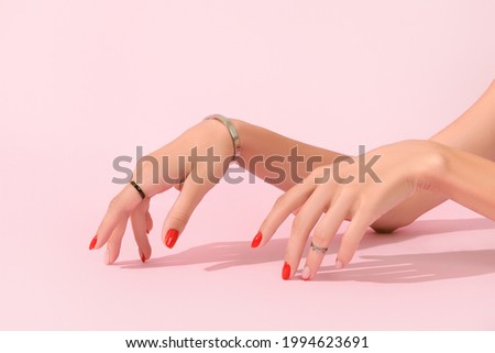 Womans hands with red manicure on pink background. Manicure design trends Royalty-Free Stock Photo #1994623691