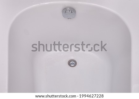 Clean white bath bowl with drain hole, close up