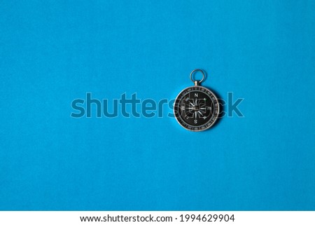 Compass on blue background. Concept signs symbols. Tool for travel, tourism, science, get lost, business and design and decoration. Flat lay design.