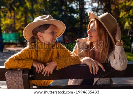 Happy Mother And Daughter Portrait In Autumn Park. Autumn Fall Time In Nature. Family On Leaves