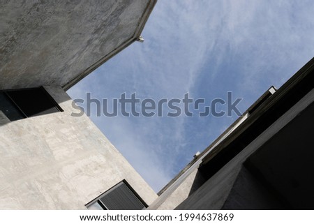 Worm Eye View of the Blue Sky Enclosed by Concrete Walls.
