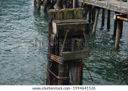 A single old dock pylon near a pier.