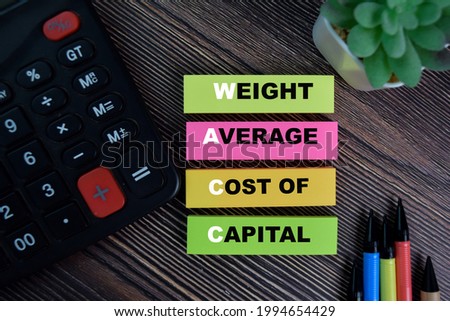 WACC - Weight Average Cost of Capital write on sticky notes isolated on Wooden Table.