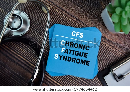 CFS - Chronic Fatigue Syndrome write on sticky notes isolated on Wooden Table. medical concept Royalty-Free Stock Photo #1994654462